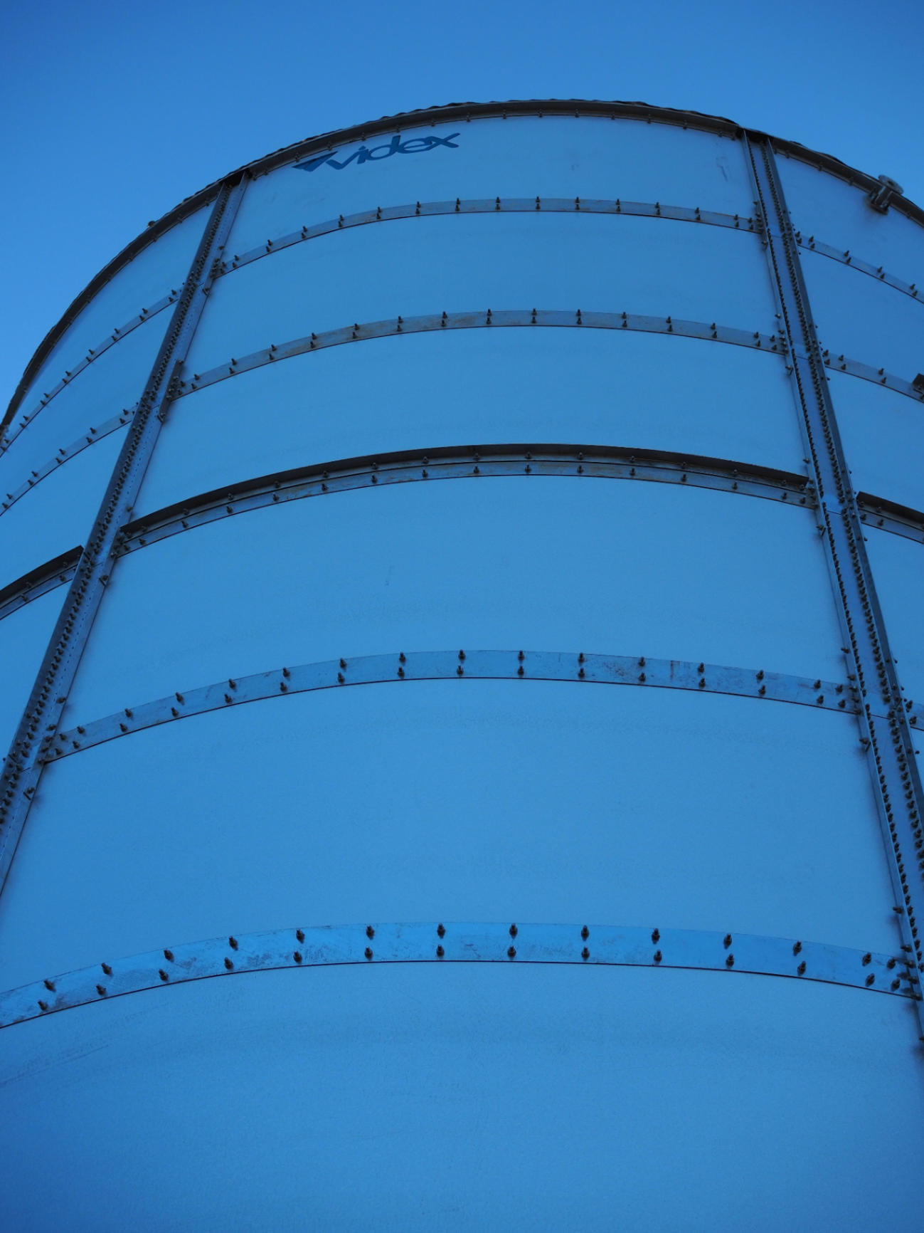 Videx branded cylindrical bolted tank at dusk